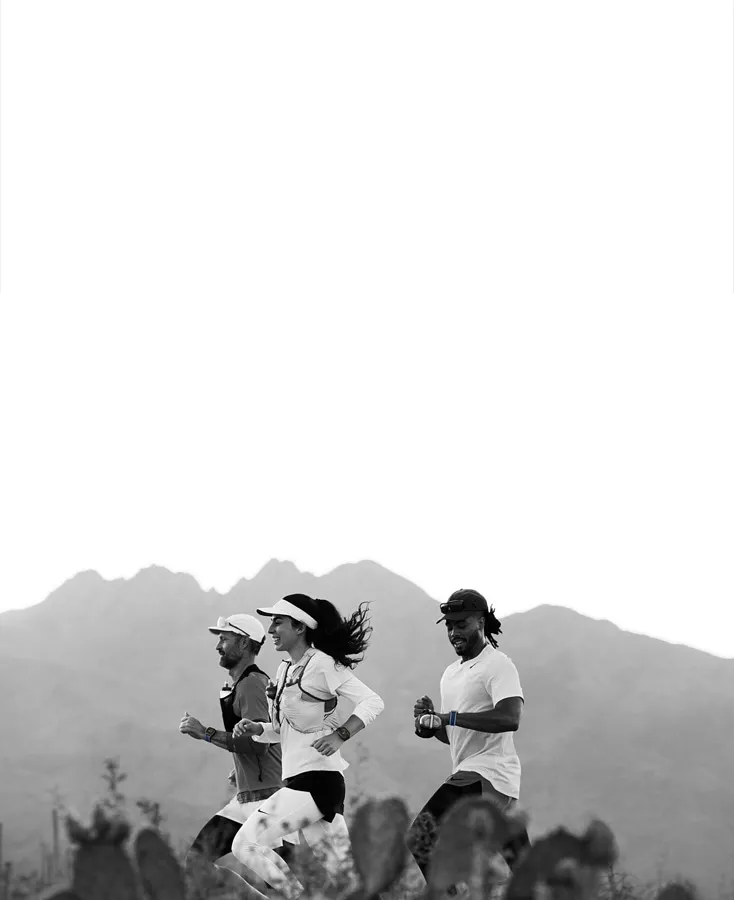 Група бігунів із Apple Watch Ultra 3 на трейловому маршруті в горах: чорно-біла естетика та професійний спорт