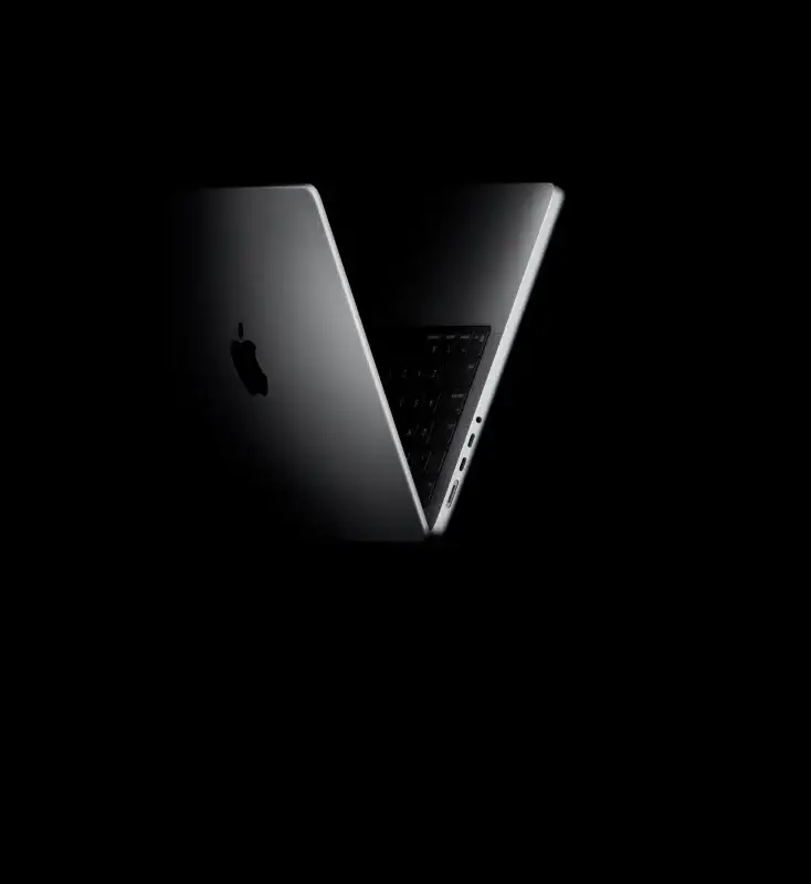 Ноутбук Apple MacBook Pro 14 M5 в алюмінієвому корпусі. Контрастне освітлення ефектно підкреслює тонкий профіль пристрою, логотип Apple на кришці та набір бічних портів для професійної роботи