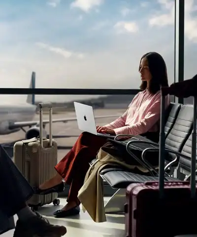 Дівчина працює за ноутбуком MacBook Pro 14 M5 у залі очікування аеропорту