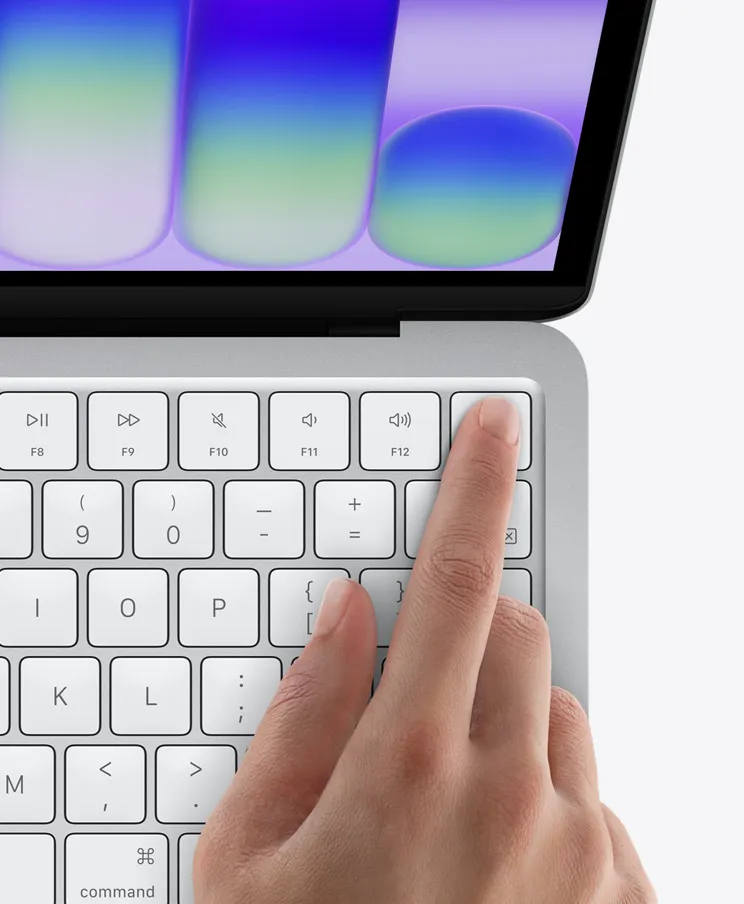 MacBook Neo, сріблястого кольору, палець людини на датчику Touch ID у верхньому правому куті клавіатури