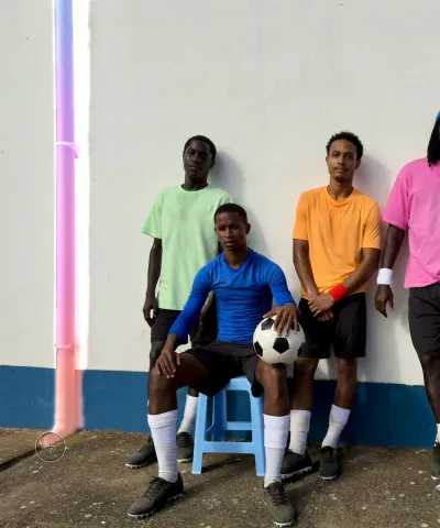 Використання інструмента «Очищення» для видалення водостічної труби з фотографії футболістів, що позують біля стіни