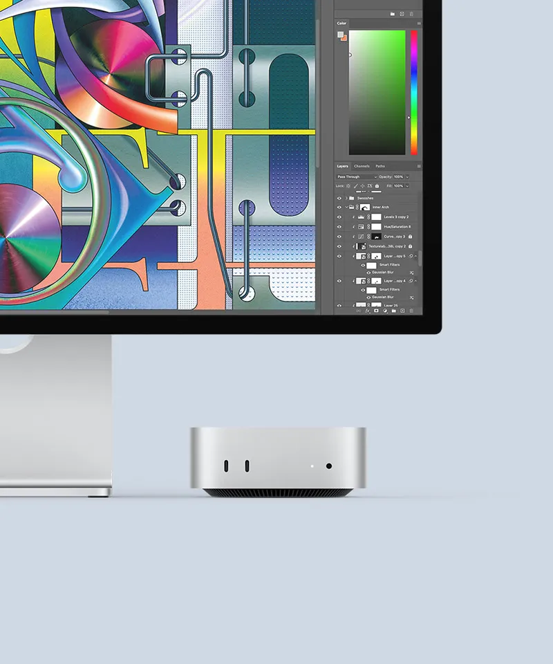 Вид спереду на сріблястий Mac mini, на передній панелі якого показано порти та світлодіодний індикатор. Його акуратно розташовано під монітором Mac, на екрані якого кольорове зображення