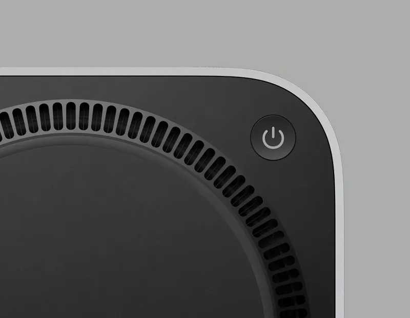 Вид на Mac mini знизу; показано чорну панель з кнопкою живлення та вентиляційні отвори по колу