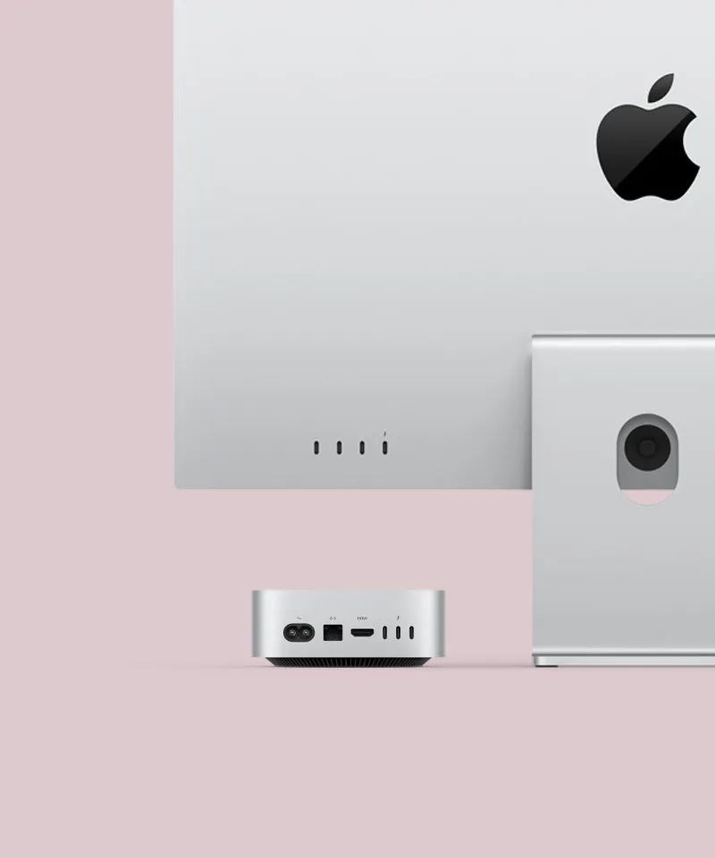Вид ззаду на сріблястий Mac mini і монітор Mac. На Mac mini, що акуратно розташований під монітором Mac, показано порти на задній панелі